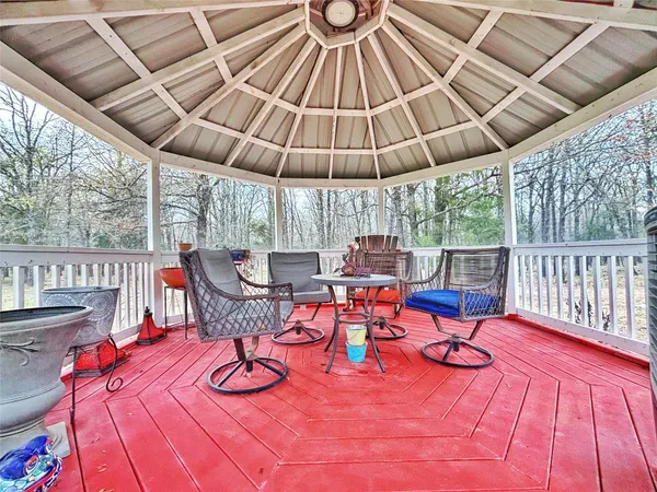 a view of a patio with a table chairs and a wooden floor