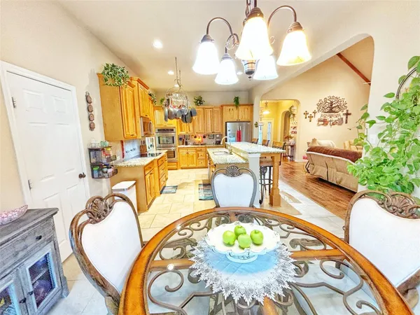 a living room with dining table and a chandelier