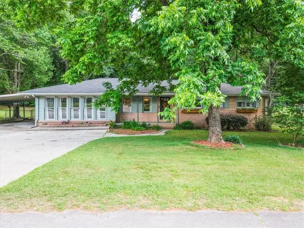 a view of a house with a backyard and a patio