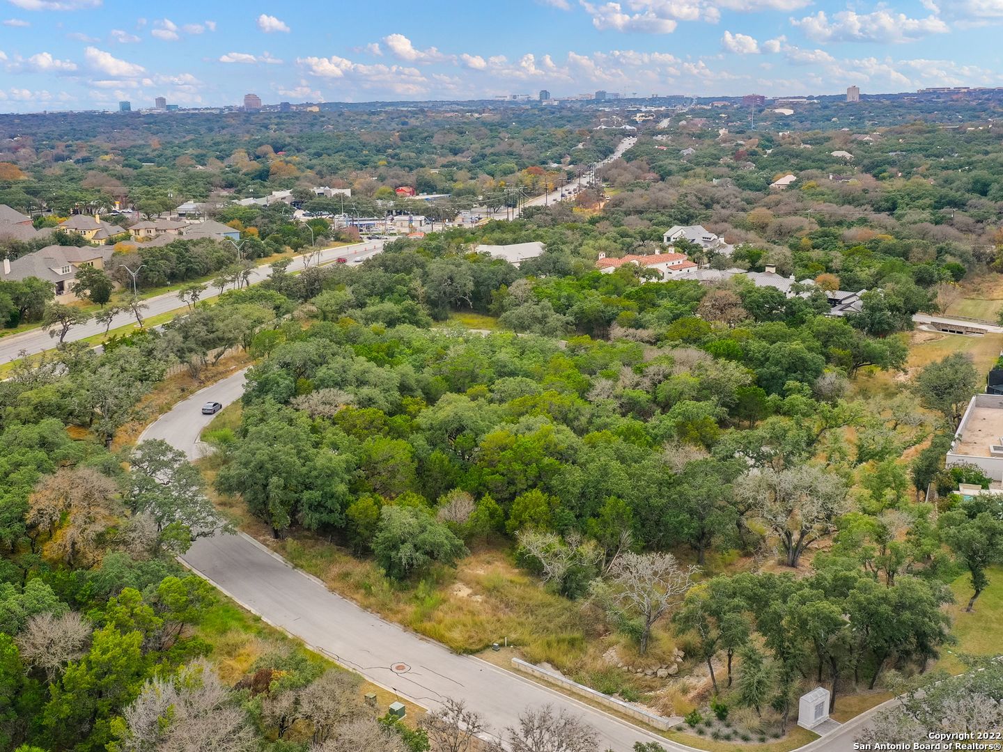 an aerial view of residential houses with outdoor space and trees