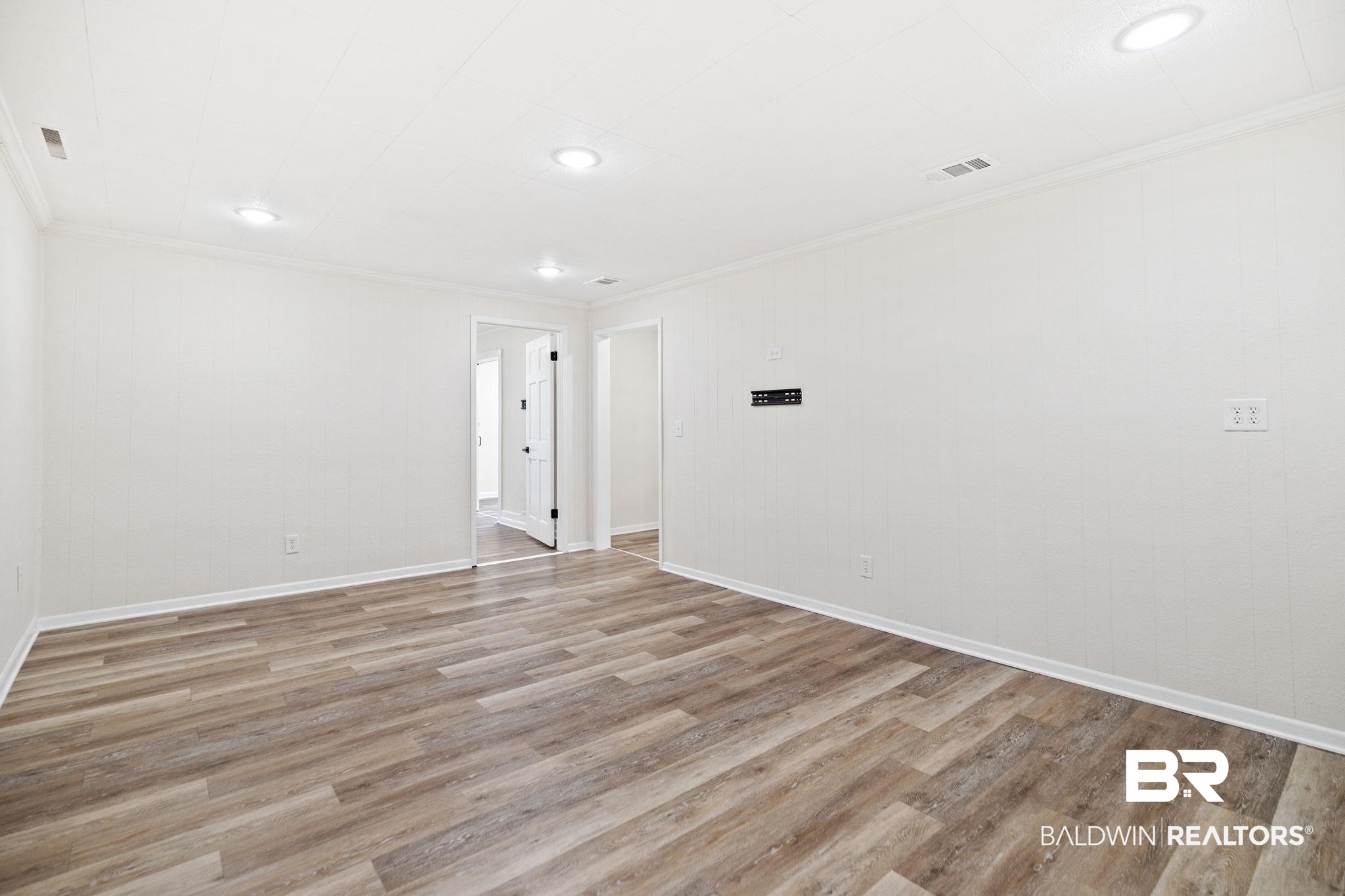 507 Byrne Street Bay Minette, AL 36507 - Photo 20 of 40 Empty room with crown molding and light wood-type flooring