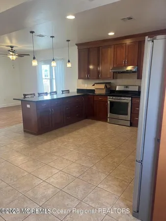 a kitchen with stainless steel appliances granite countertop a stove a sink and a refrigerator