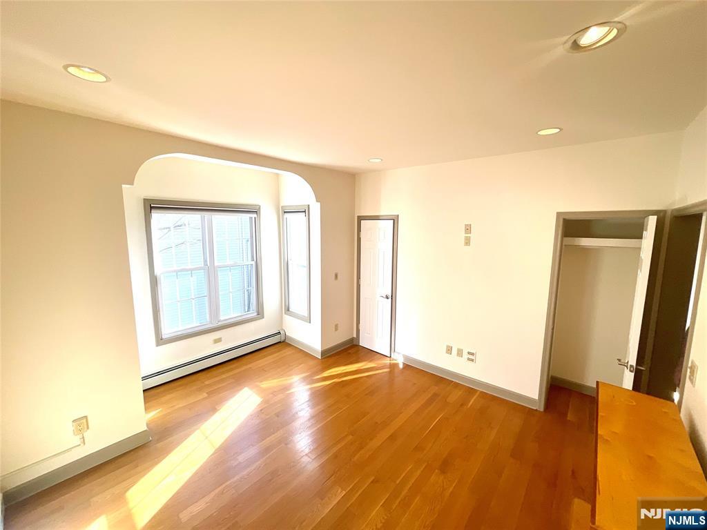 49 East Passaic Avenue, Unit 2 Rutherford, NJ 07070 - Photo 9 of 23 an empty room with wooden floor and windows