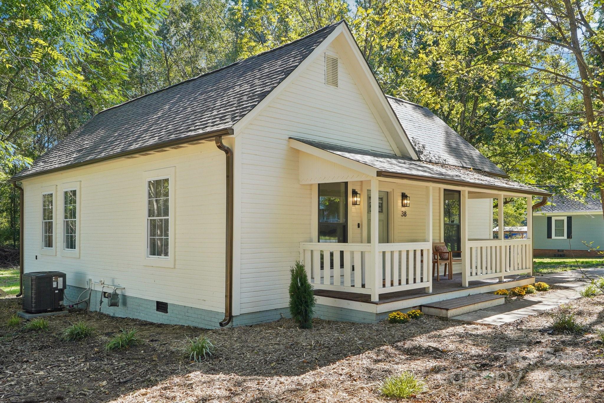 a view of a house with wooden fence next to a yard