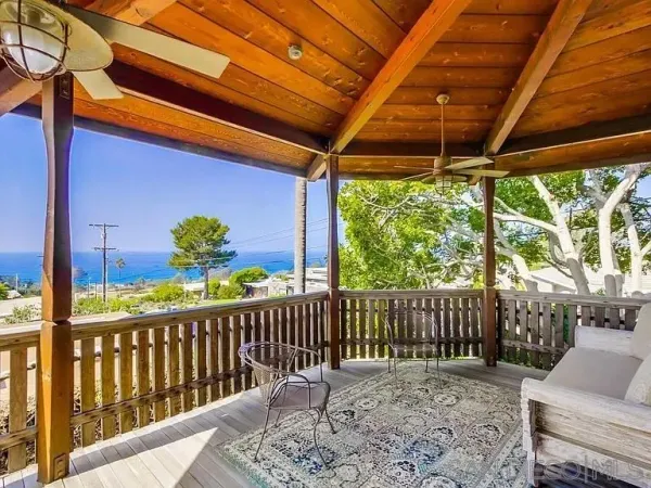a view of a porch with furniture and a yard