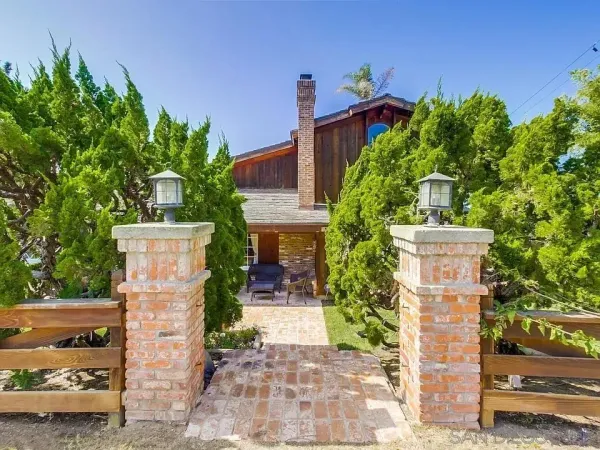 a front view of a house with a yard and trees
