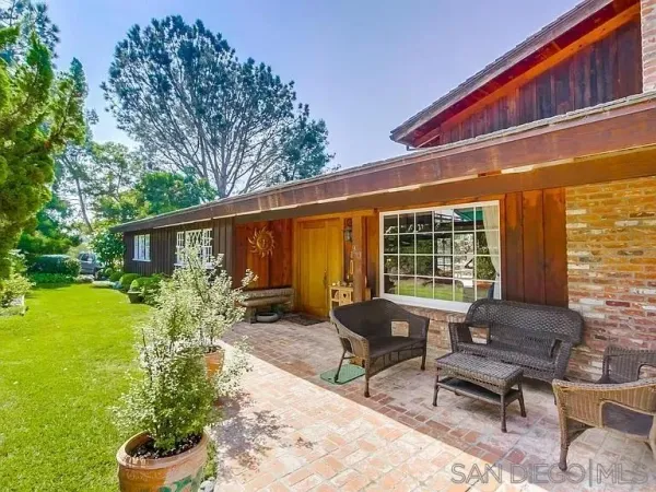 a view of a house with backyard sitting area and garden