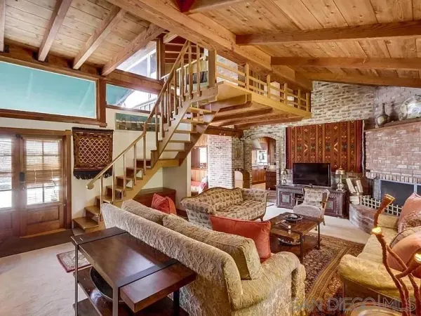 a living room with furniture a fireplace and a ceiling fan