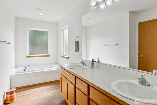 a bathroom with a tub sink and mirror