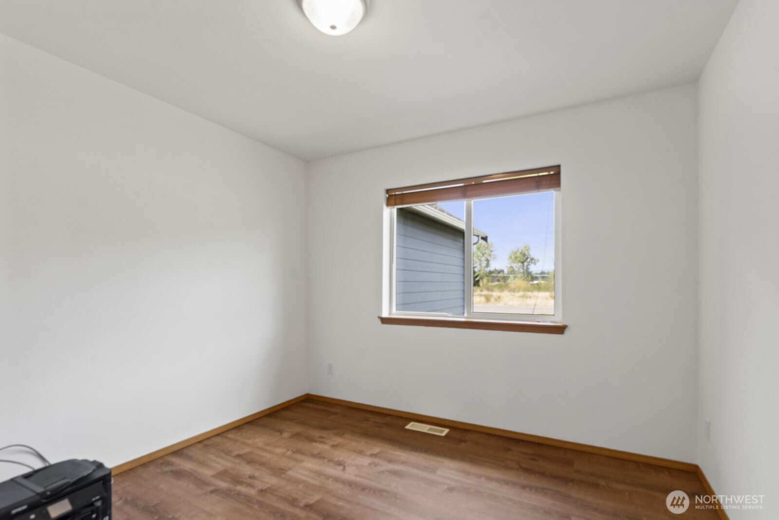7245 185th Lane Southwest Rochester, WA 98579 - Photo 18 of 29 a view of an empty room with wooden floor and a window