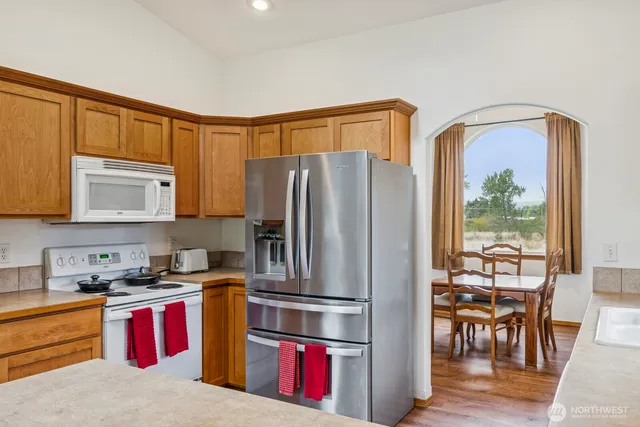 a kitchen with stainless steel appliances granite countertop a refrigerator and a stove top oven