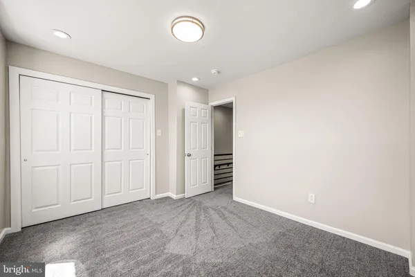 an empty room with closet and entryway