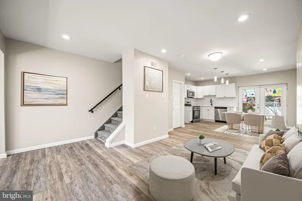 a living room with furniture and a wooden floor