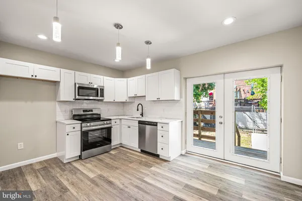 a kitchen with stainless steel appliances granite countertop a stove top oven a sink and a refrigerator