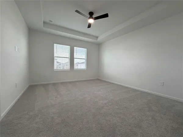 an empty room with a window and a ceiling fan
