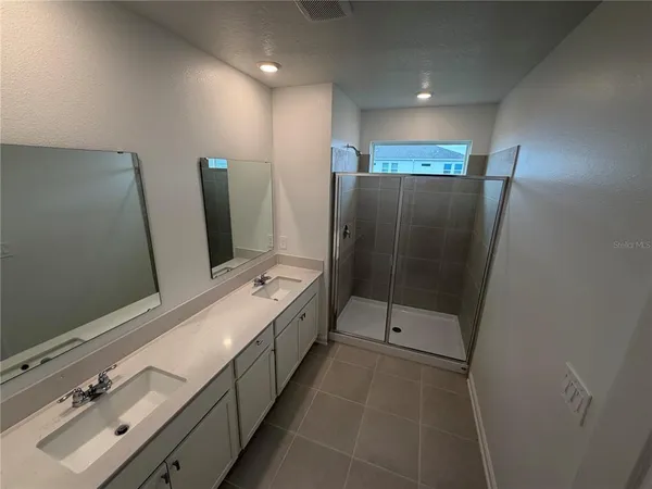 a bathroom with a double vanity sink and mirror