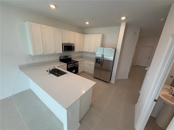 a kitchen with stainless steel appliances a refrigerator and a stove top oven