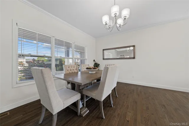 a view of a dining room with furniture a chandelier and wooden floor