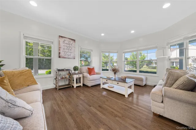 a kitchen with a sink stove and white cabinets with wooden floor
