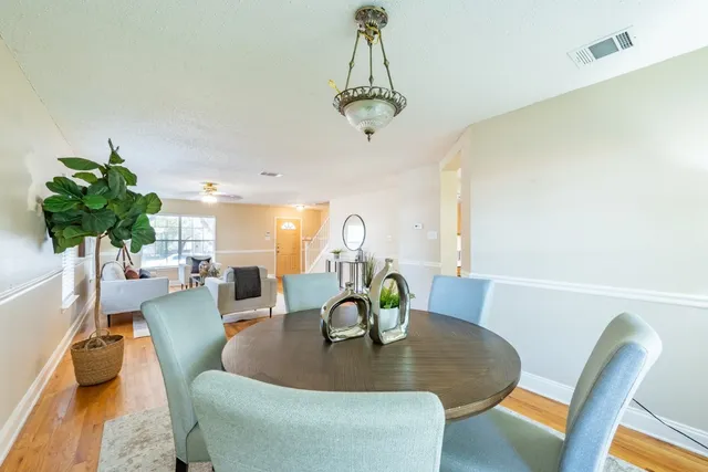 a living room with dining table and a potted plant