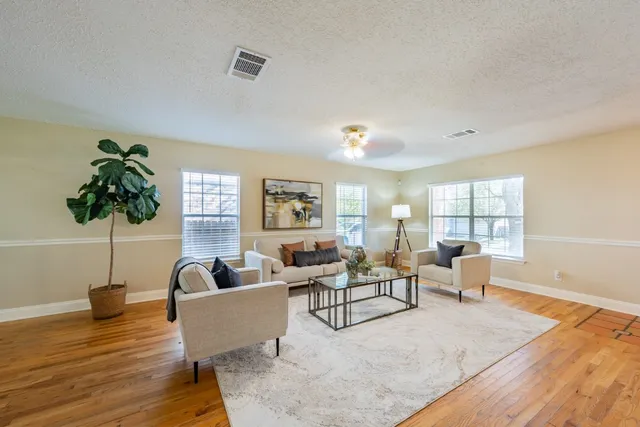 a living room with furniture and a wooden floor
