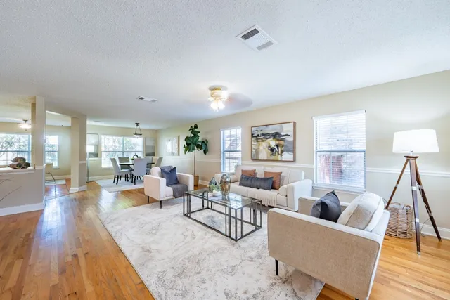 a living room with furniture and a wooden floor