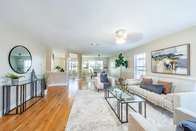 a living room with furniture a rug and a large window
