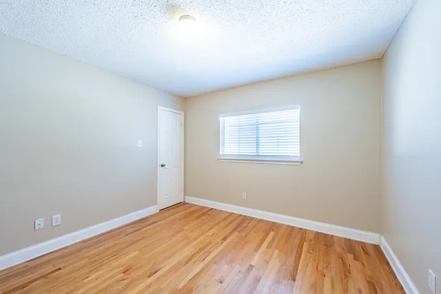 a view of a room with wooden floor and white walls