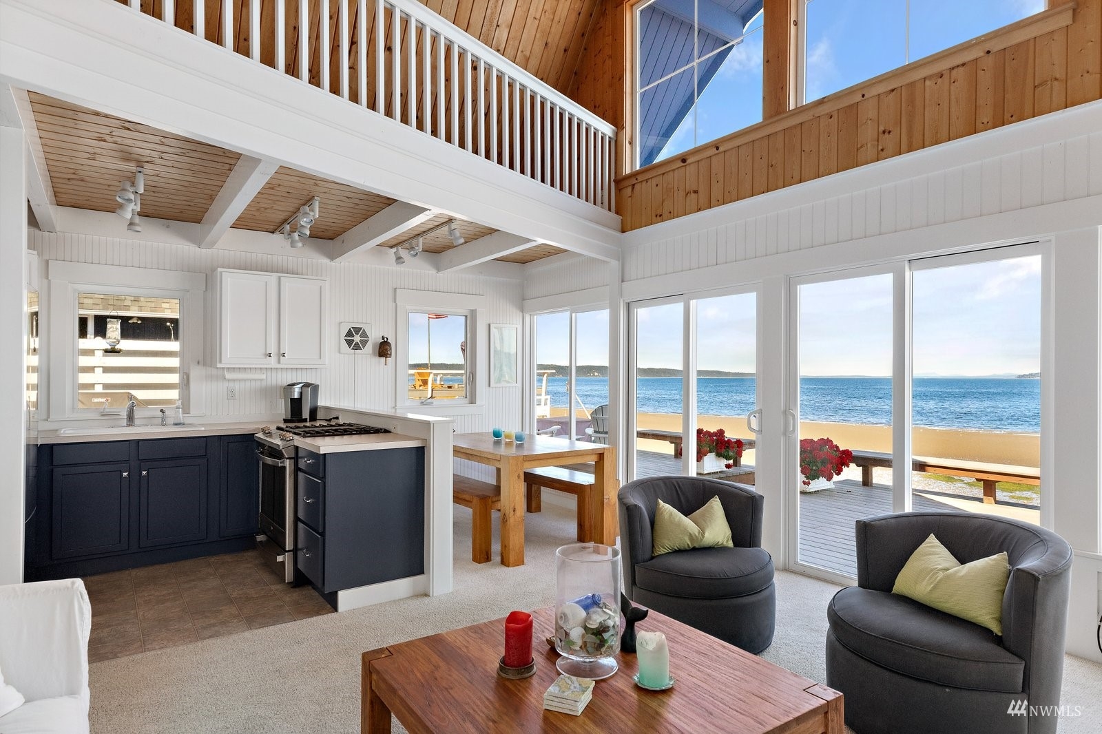 2139 Eastpoint Drive Langley, WA 98260 - Photo 10 of 40 a living room with furniture floor to ceiling window and kitchen view