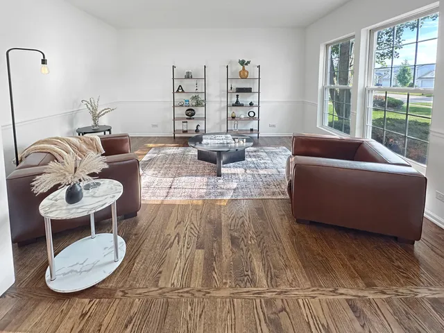 a view of a livingroom with wooden floor and furniture