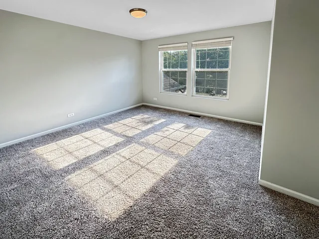 a view of an empty room with wooden floor and stairs