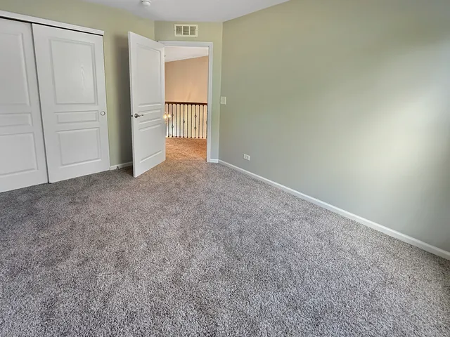 a white bed sitting in a room next to a window