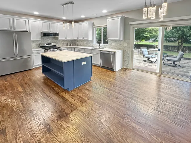a kitchen with stainless steel appliances granite countertop a sink stove and refrigerator