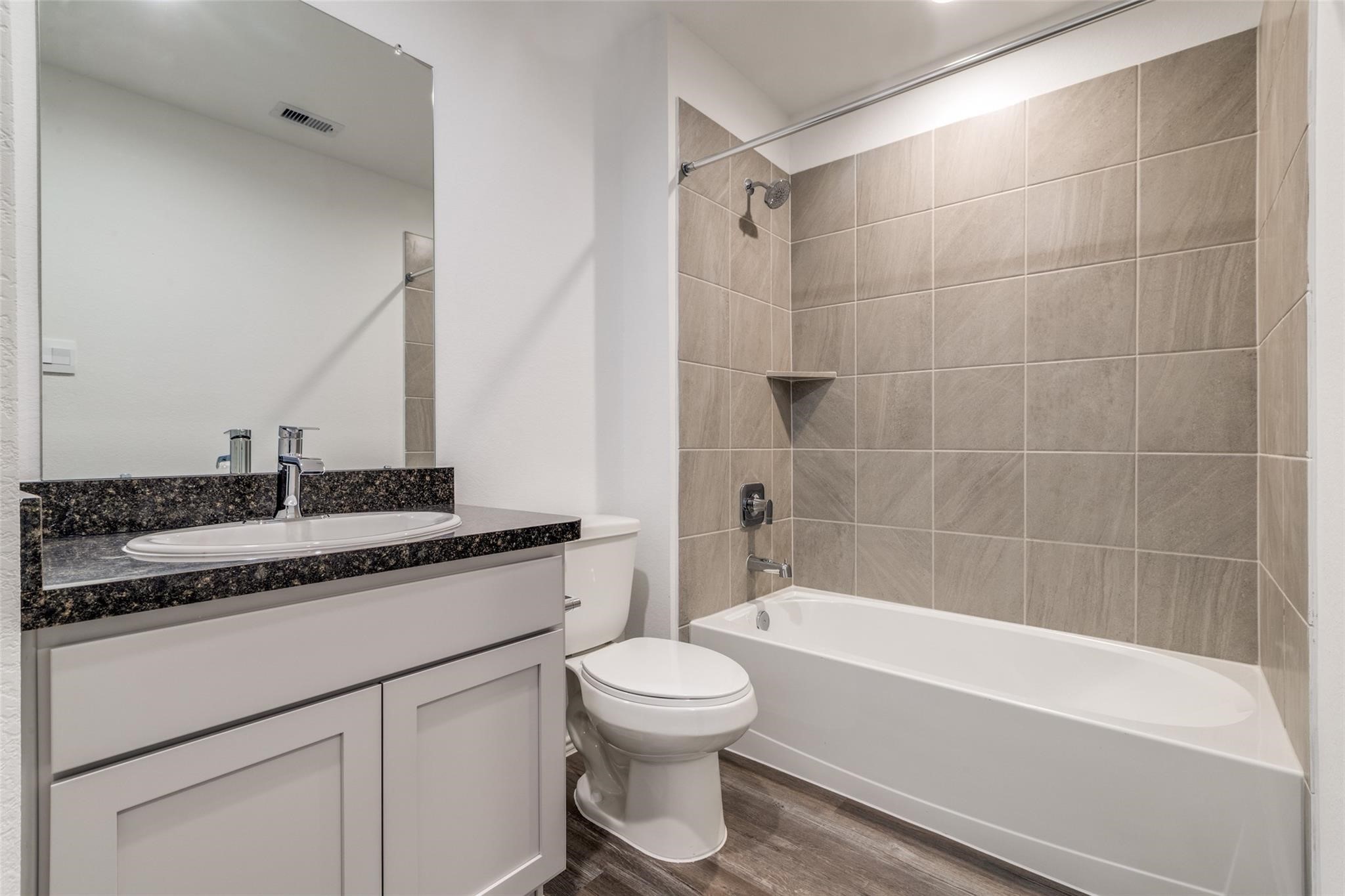 24323 Cayman Heights Lane Spring, TX 77373 - Photo 4 of 12 a bathroom with a granite countertop sink a toilet and bathtub
