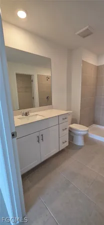 a white toilet sitting in a spacious bathroom next to a window
