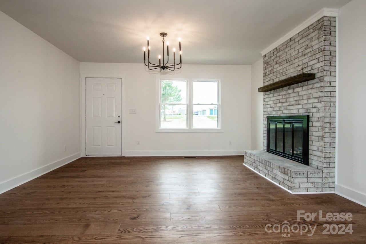 4892 Highway 16 Denver, NC 28037 - Photo 16 of 46 a view of an empty room with wooden floor fireplace and a window