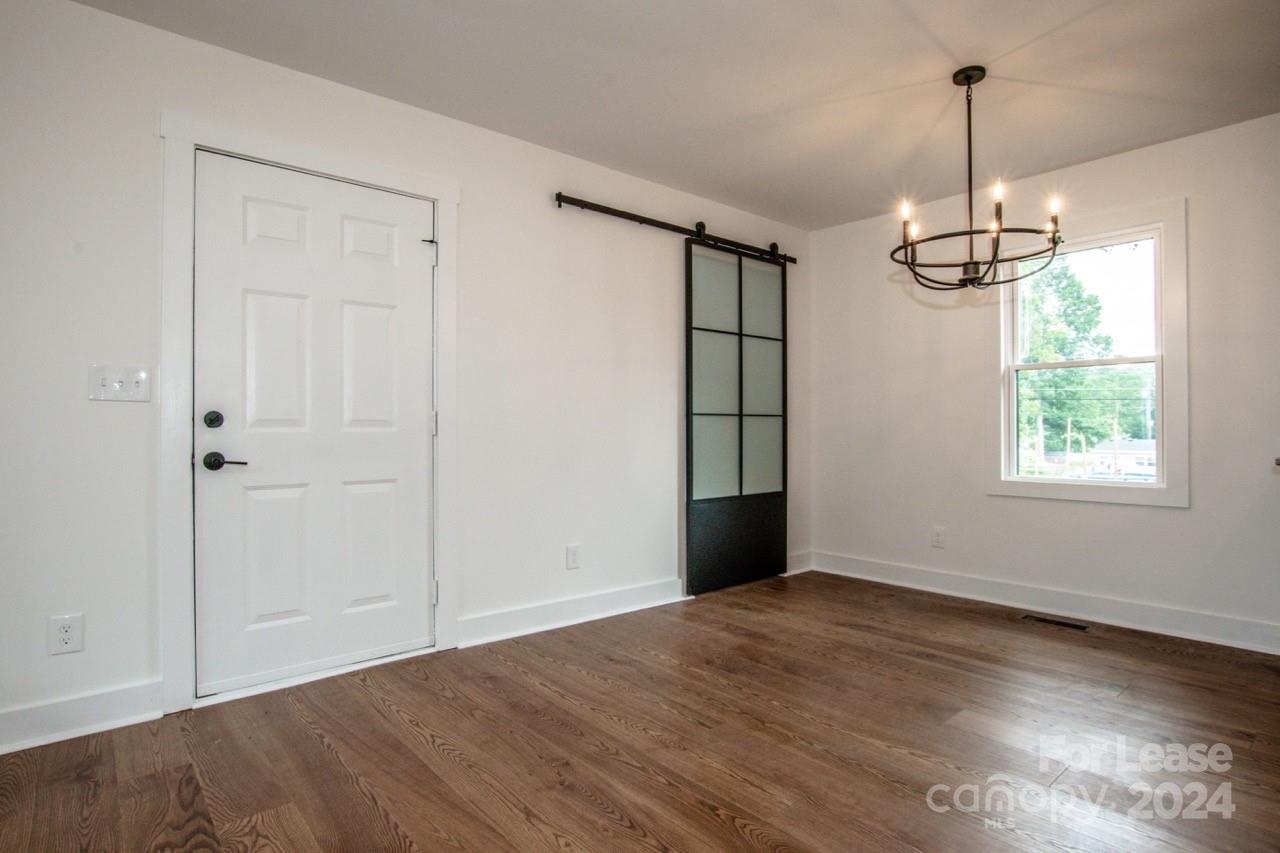 4892 Highway 16 Denver, NC 28037 - Photo 17 of 46 an empty room with wooden floor windows and ceiling fan