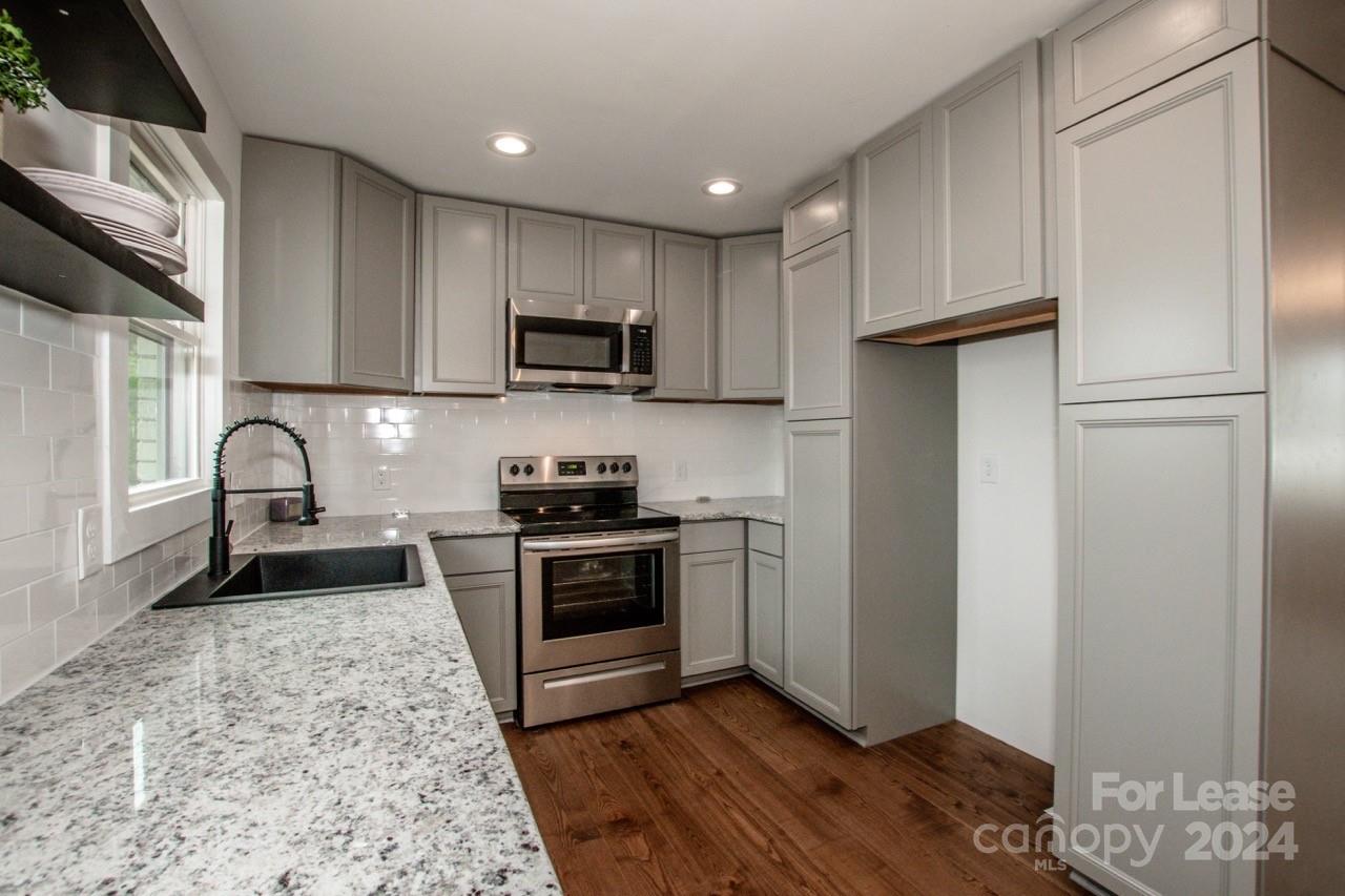 4892 Highway 16 Denver, NC 28037 - Photo 20 of 46 a kitchen with stainless steel appliances granite countertop a refrigerator stove top oven and sink