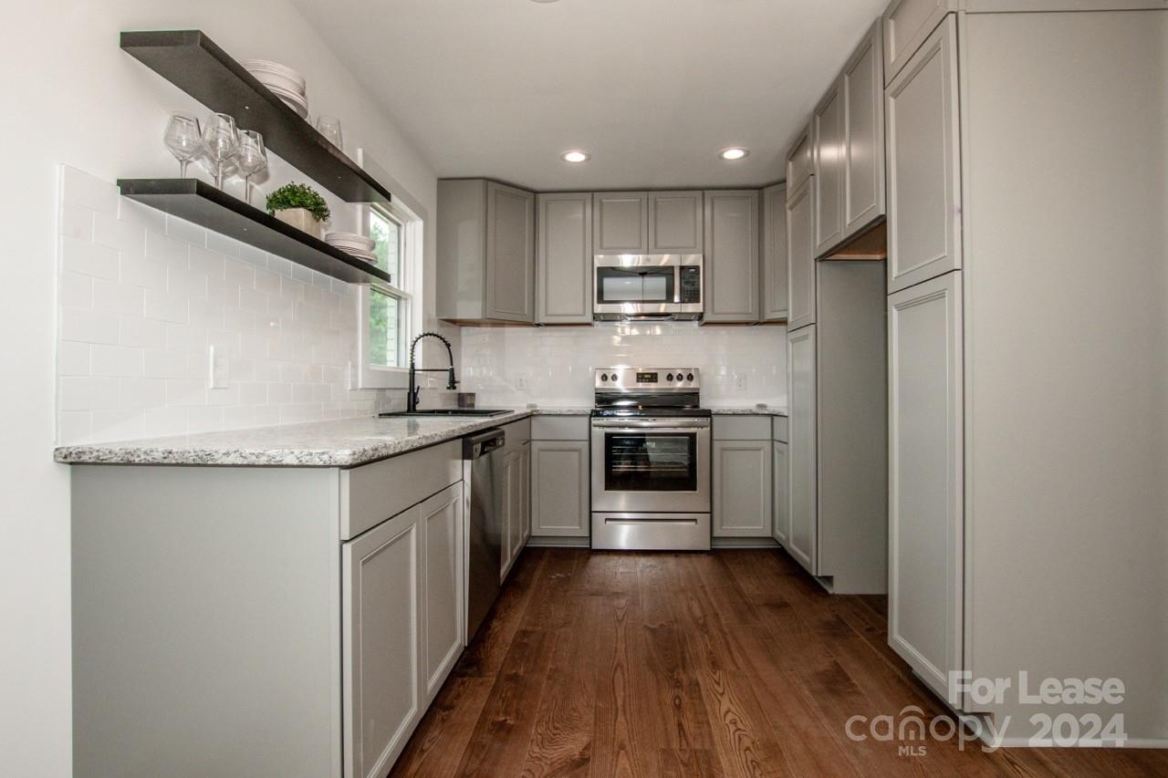 4892 Highway 16 Denver, NC 28037 - Photo 21 of 46 a kitchen with stainless steel appliances a sink stove refrigerator and cabinets
