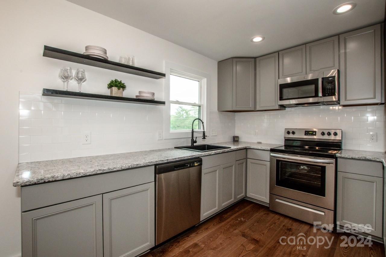 4892 Highway 16 Denver, NC 28037 - Photo 22 of 46 a kitchen with stainless steel appliances granite countertop a sink and stove top oven