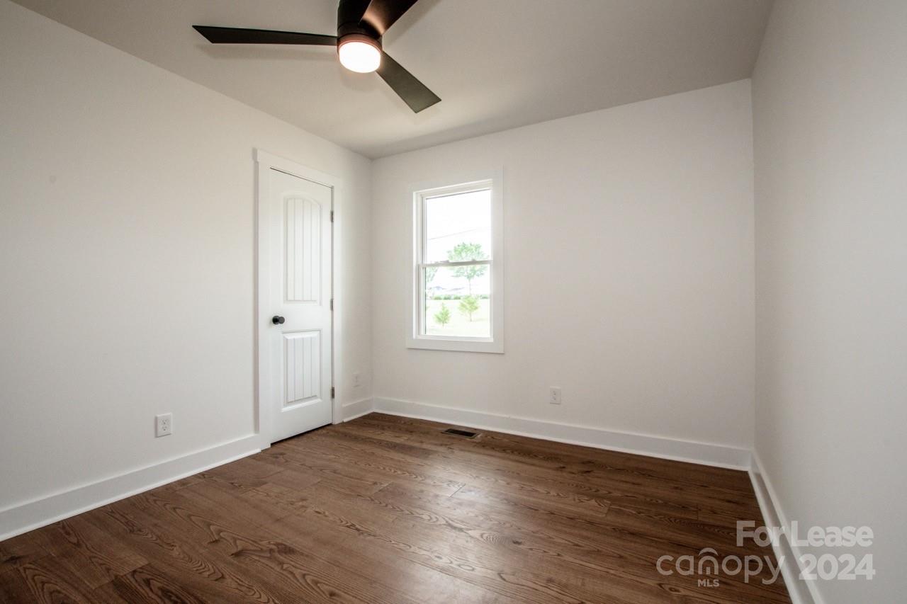 4892 Highway 16 Denver, NC 28037 - Photo 31 of 46 an empty room with wooden floor and windows