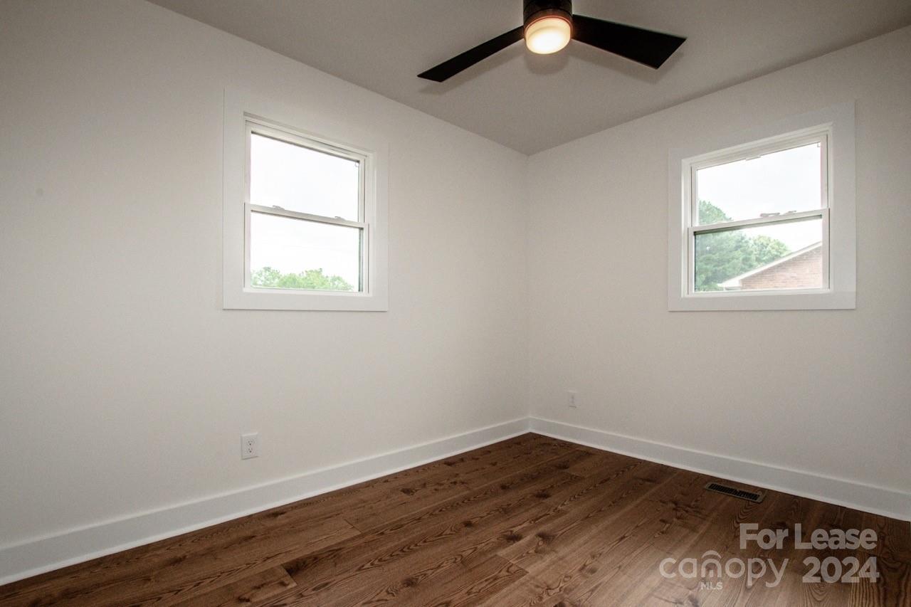 4892 Highway 16 Denver, NC 28037 - Photo 35 of 46 an empty room with wooden floor ceiling fan and windows
