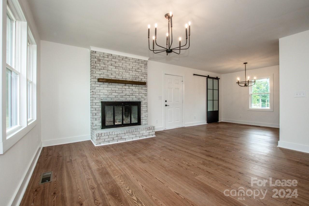 4892 Highway 16 Denver, NC 28037 - Photo 10 of 46 a view of empty room with wooden floor and fireplace