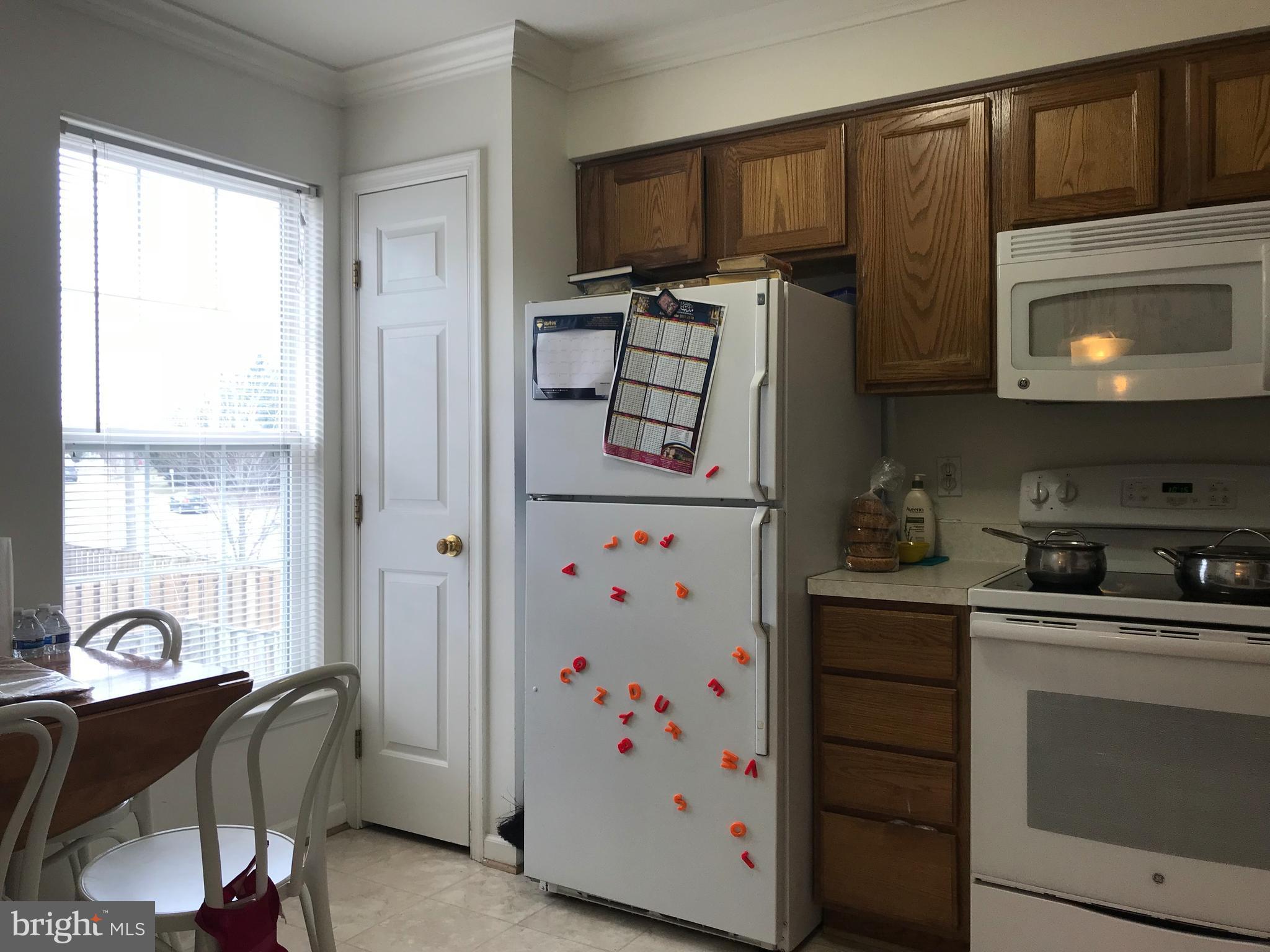 6389 Trips Way Springfield, VA 22150 - Photo 9 of 22 a kitchen with stainless steel appliances a stove a sink cabinets and a window