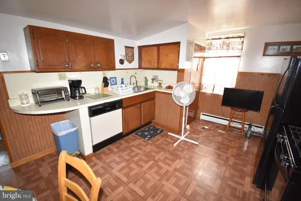 a kitchen with stainless steel appliances granite countertop a stove top oven a sink dishwasher and cabinets with wooden floor