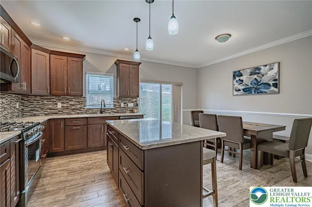 a kitchen with a stove a sink a microwave a dining table and chairs