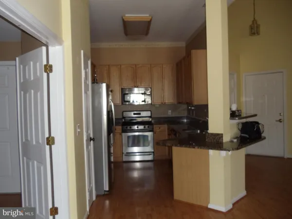 a kitchen with kitchen island granite countertop a refrigerator and a stove top oven