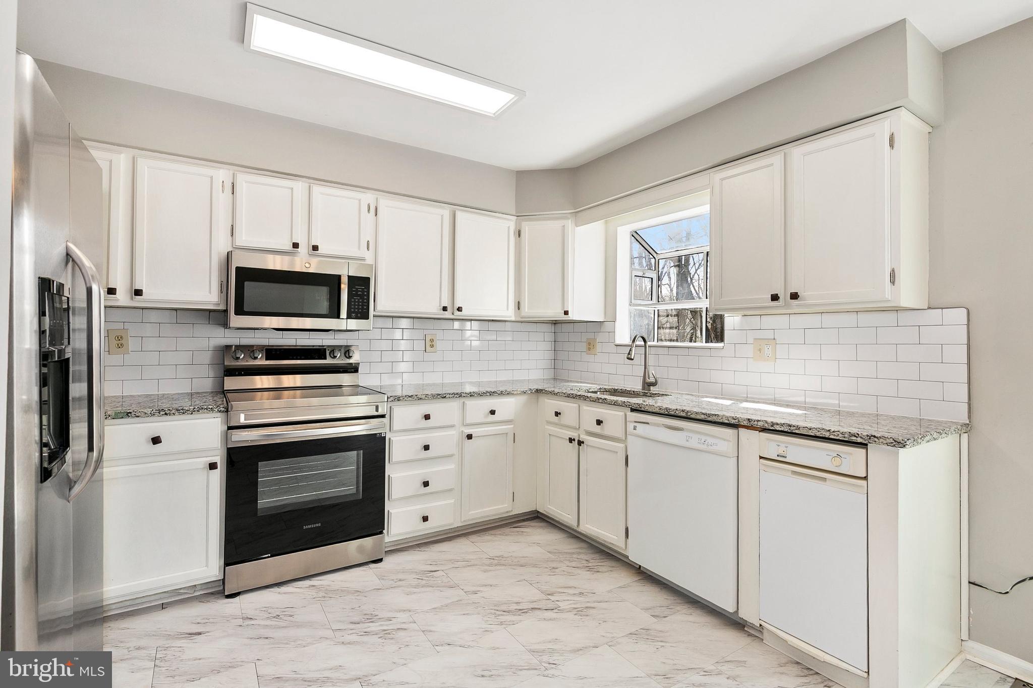 4762 Leyden Way Ellicott City, MD 21042 - Photo 17 of 58 a kitchen with granite countertop white cabinets stainless steel appliances and a sink