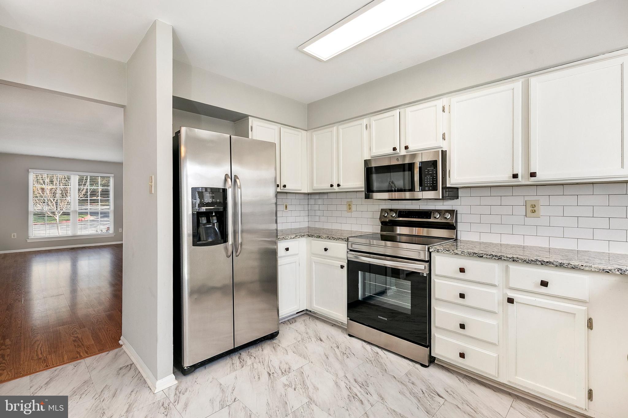 4762 Leyden Way Ellicott City, MD 21042 - Photo 18 of 58 a kitchen with white cabinets stainless steel appliances and a counter space