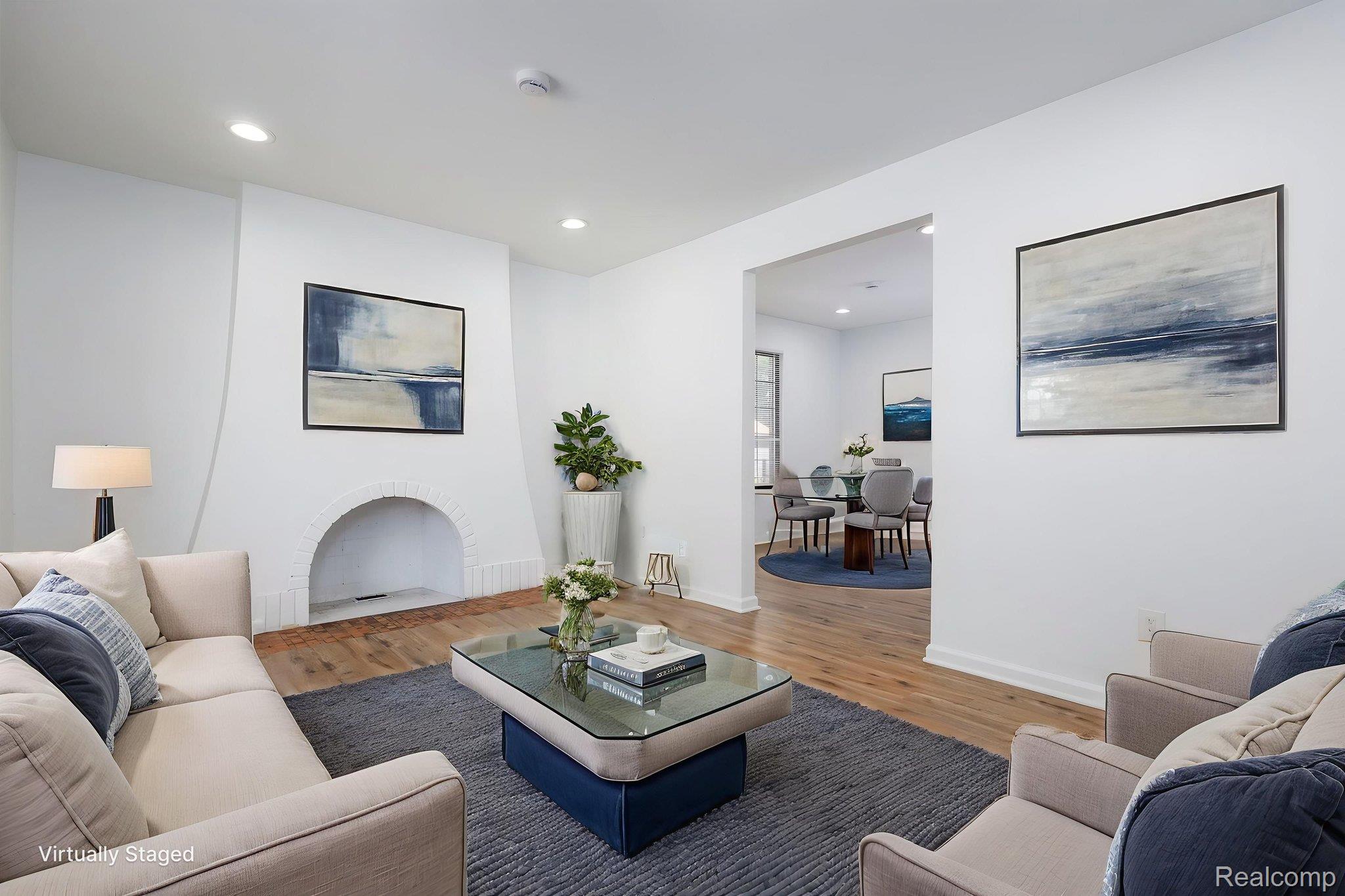 3974 Devonshire Road Detroit, MI 48224 - Photo 4 of 15 Spacious living area featuring light wood-finish flooring, recessed lighting, and a white brick fireplace with an arched opening